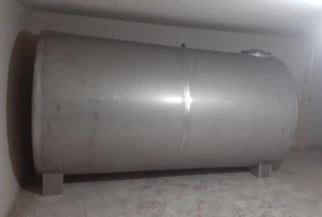 Depo odasında ayaklar üzerinde duran paslanmaz yatay silindirik su deposu ve gövdedeki çevresel kaynak dikişi